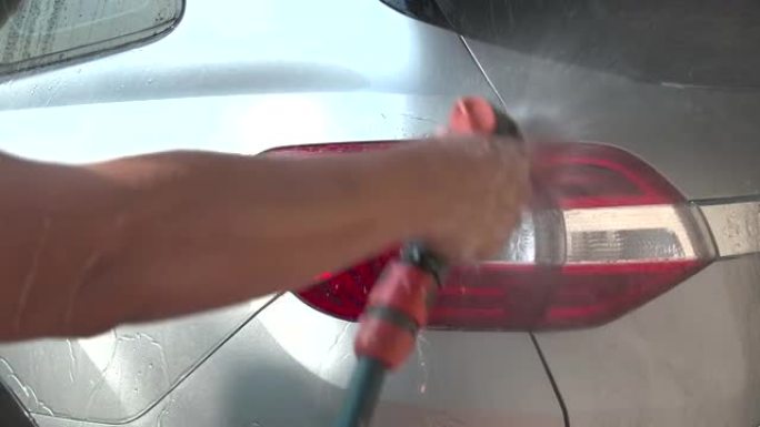 通过清洗洗发水和喷水，水清洗汽车来关闭一名男子洗车