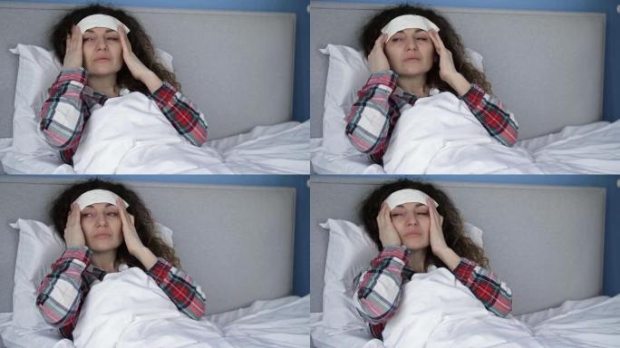 一位患有头痛并在额头上拿着冷湿敷的生病妇女的肖像。偏头痛，宿醉或高发热