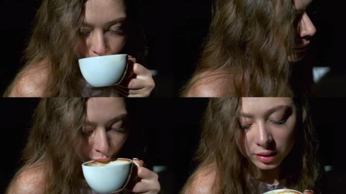 女孩从白杯中愉快地喝咖啡的特写镜头