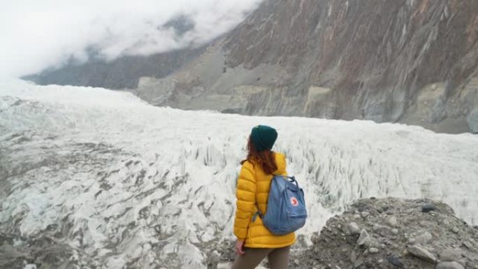 穿着黄色夹克的女人看着巴基斯坦的冰川