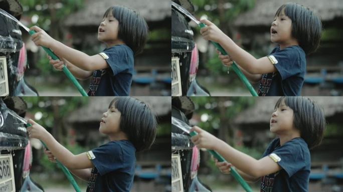 亚洲小女孩喜欢在前院洗车。