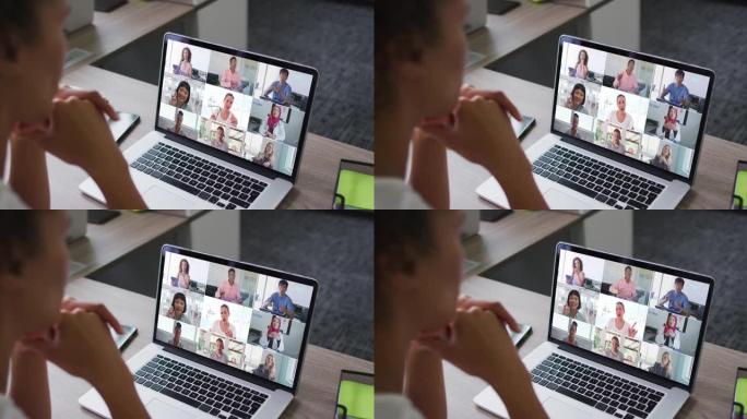 非裔美国妇女与办公室同事在笔记本电脑上进行视频会议
