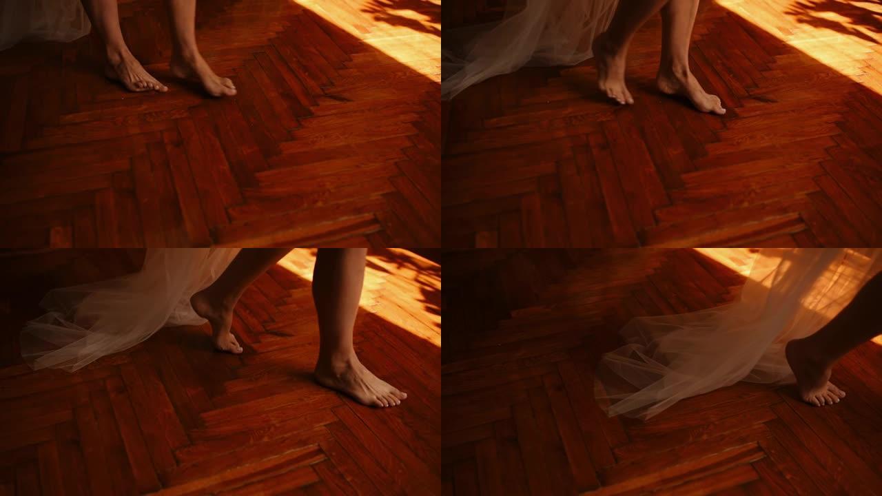 新娘赤脚在木制棕色镶木地板上慢慢走路，长长的雪纺面纱在她身后，紧随其后