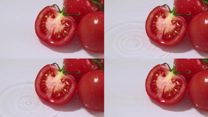 新鲜多汁的意大利西红柿躺在水中，水滴落下。天然闪亮生物有机蔬菜健康饮食