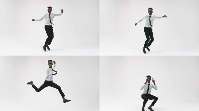 穿着办公室西装的年轻黑人男子在白色背景上跳跃并欢欣鼓舞。黑人公司办公室男子在工作室里欢呼雀跃