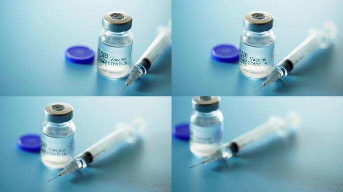 医用疫苗小瓶，带有在蓝色背景下的工作室中布置的注射器。