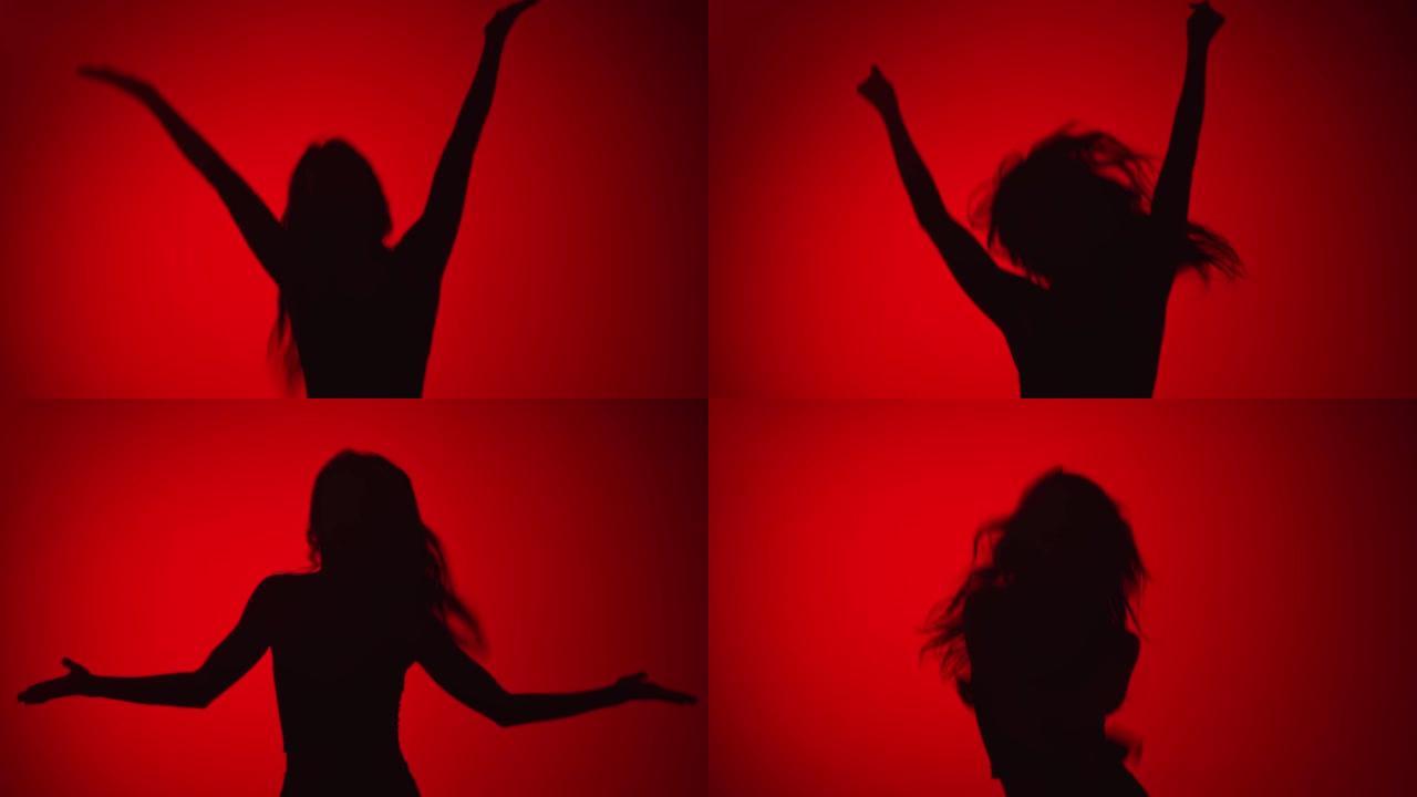 剪影快乐的女人跳跃享受自由孤立在红色。用4K红色相机拍摄