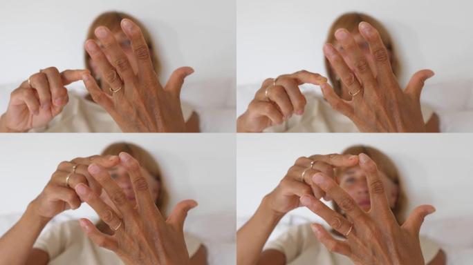 中年女性检查手腕和手指。手头特写