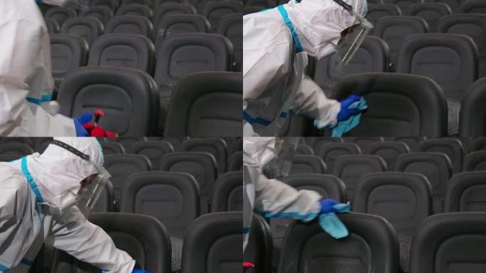 穿着特殊衣服的男人为看电影的人擦椅子。
