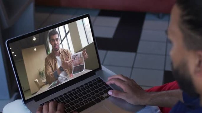 中东男子在笔记本电脑上与男性办公室同事进行视频通话