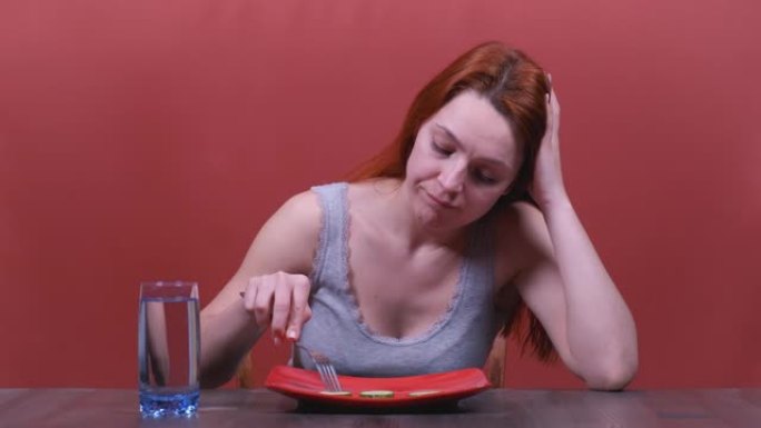 年轻女子感到悲伤和无聊的饮食不想吃蔬菜