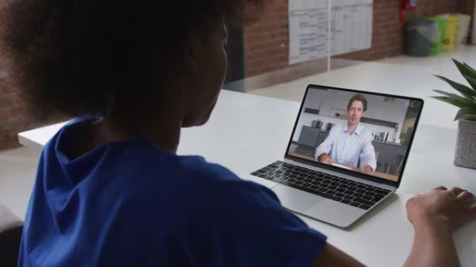 非裔美国妇女在办公室的笔记本电脑上与男同事进行视频通话