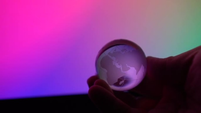 透明地球亲手在霓虹色背景上旋转抽象控制