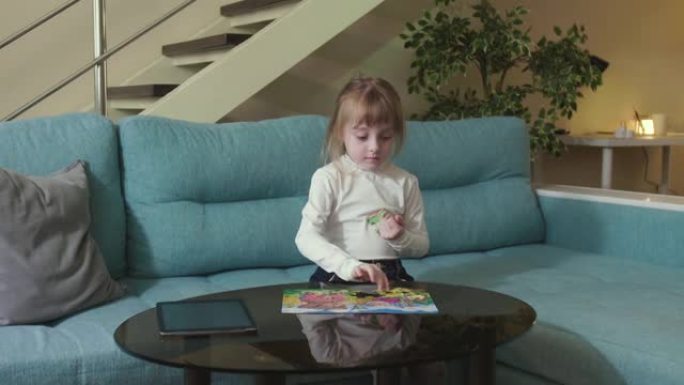一个好奇的小女孩坐在客厅的沙发上，拼凑拼图