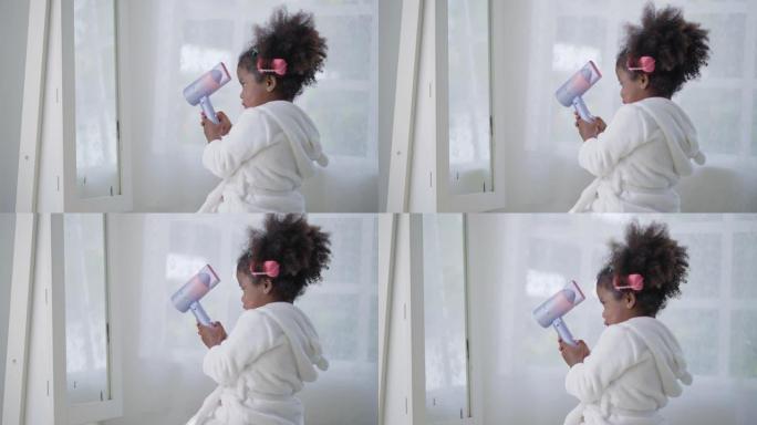 一个非洲孩子的侧视图，她的头发上有一个塑料卷发器，用吹风机吹着头发，使她在家里的卧室里变得美丽。学龄