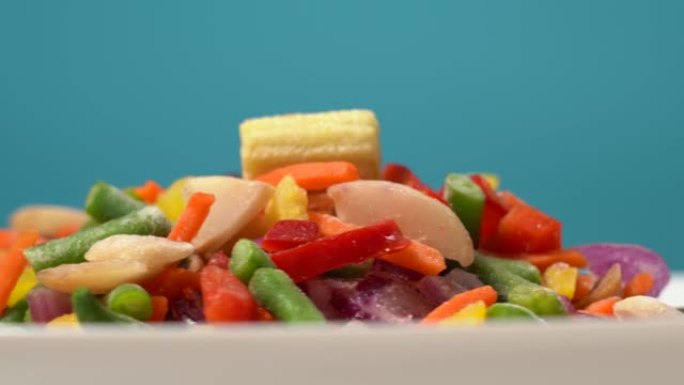 混合冷冻蔬菜掉落在白色盘子上