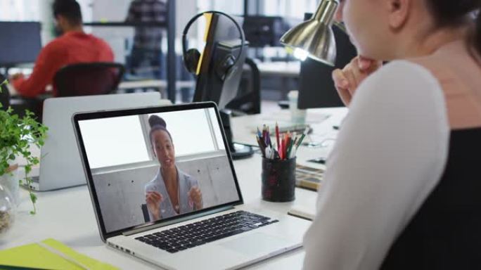 白人妇女在办公室的笔记本电脑上与女办公室同事进行视频通话