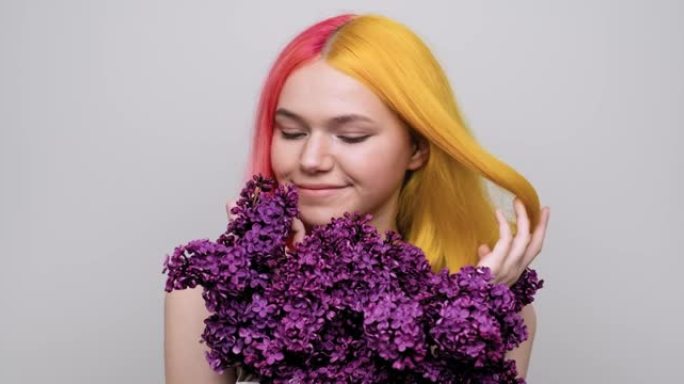 染成紫色黄色头发的少女手里拿着丁香花