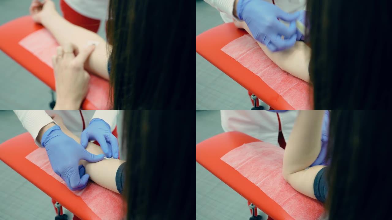 康复中心年轻女性患者静脉采血后，护士用注射器将贴片放在穿刺部位