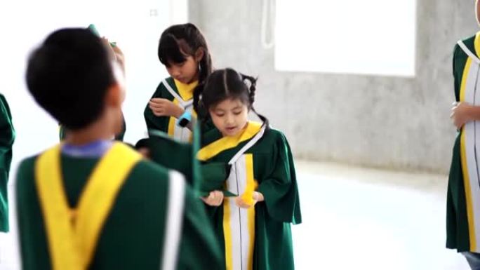 童年学生和朋友穿着毕业礼服