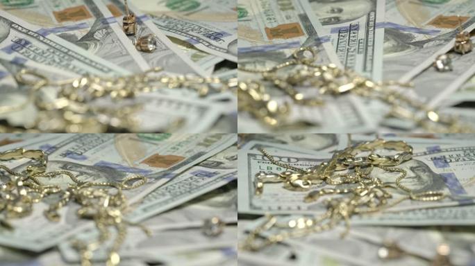 金耳环手链和项链躺在一百美元上