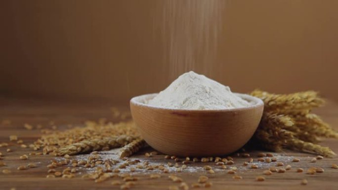 木桌上的小麦粉，小麦粒和小穗。筛面粉。