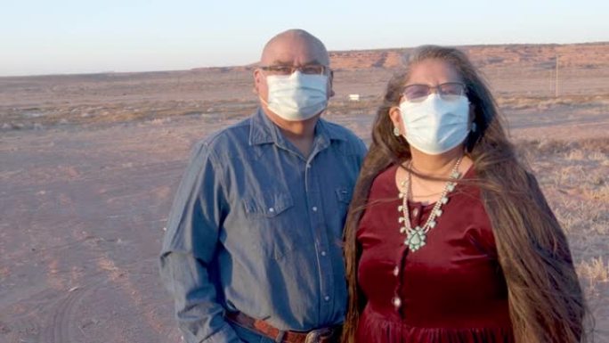 美国原住民夫妇在犹他州纪念碑谷的家附近戴着防护口罩，视频剪辑