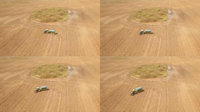 农用拖拉机喷洒肥料的鸟瞰图。