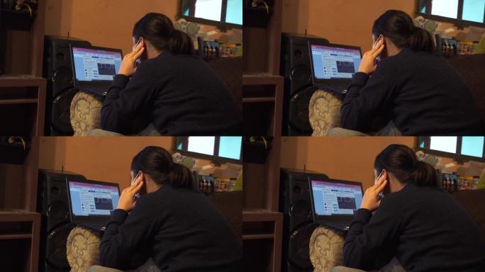 一名妇女在客厅里用笔记本电脑工作并看着她的facebook