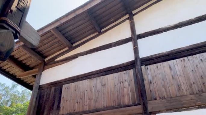 亚洲传统木制建筑的低角度旋转镜头，悬挂灯笼的屋顶屋檐和楼上阳台栏杆，福建福州，中国。4k