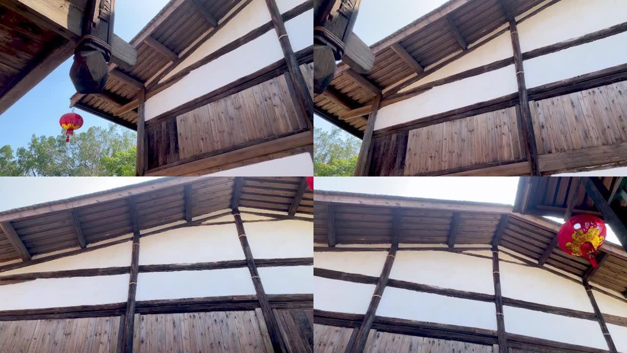 亚洲传统木制建筑的低角度旋转镜头，悬挂灯笼的屋顶屋檐和楼上阳台栏杆，福建福州，中国。4k