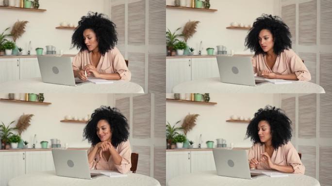 可爱的非洲裔美国妇女使用手机进行视频通话。黑色黑发女人，卷发，坐在明亮的厨房里摆姿势。慢动作就绪，4