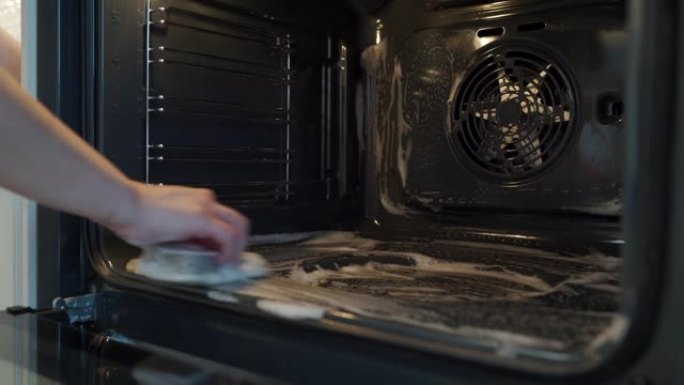 家庭主妇做家务妇女在厨房用抹布清洁烤箱
