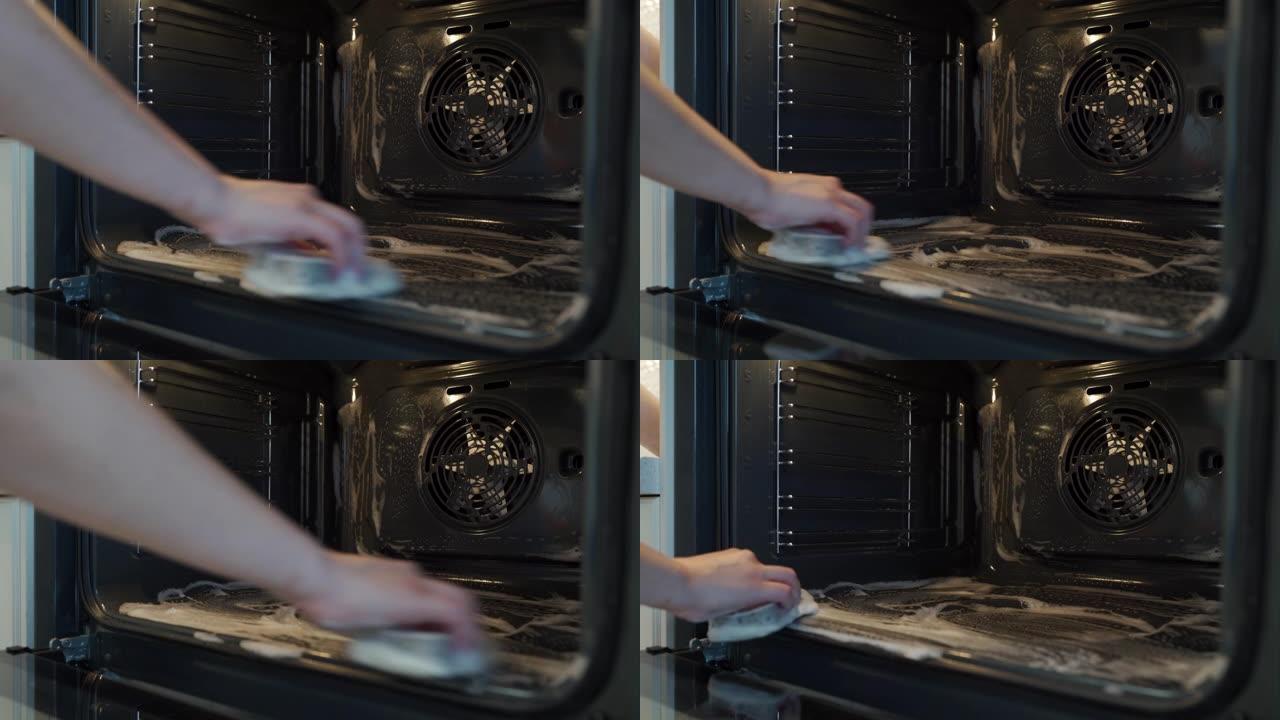 家庭主妇做家务妇女在厨房用抹布清洁烤箱