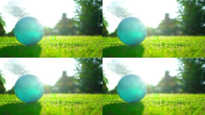 日落时绿草上的蓝色球