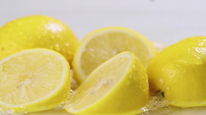 柠檬躺在水中，水滴随着飞溅而掉落。新鲜的天然柑橘类水果柠檬。维生素c，健康饮食