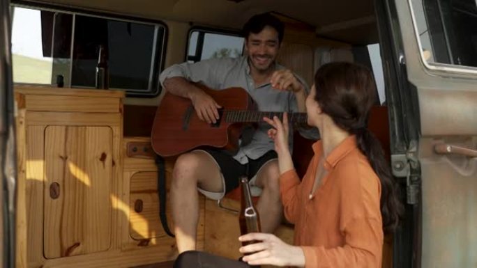 浪漫的情侣在露营时一起弹吉他和唱歌。
