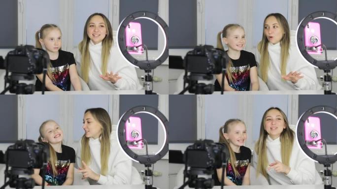 妈妈和女儿正在智能手机摄像头上录制视频博客。