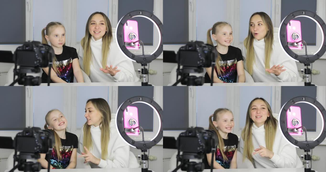 妈妈和女儿正在智能手机摄像头上录制视频博客。