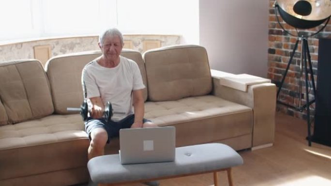 成年男子和成熟的老人用哑铃工作身体-一个男人在室内快乐训练坐在沙发上