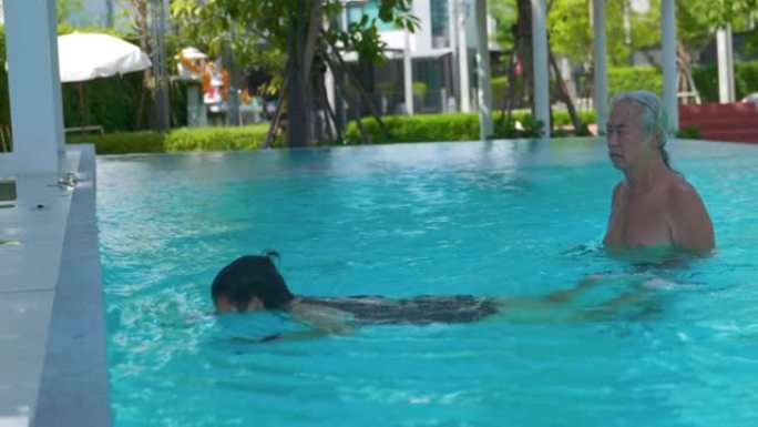 资深亚洲男子教女人游泳，资深夫妇。