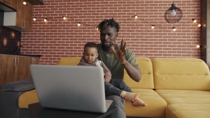 肖像非洲裔美国父亲和学龄前儿童在对话视频中讲话，问候手势