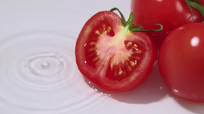 成熟多汁的意大利西红柿躺在水中，水滴落下。天然生物有机蔬菜或水果健康饮食