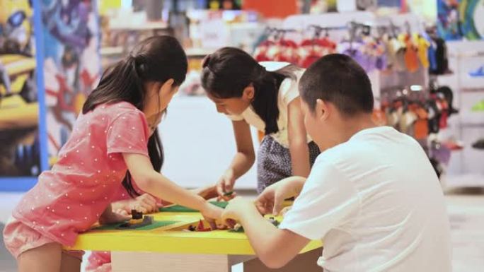 亚洲儿童在百货商店玩具中心一起玩玩具积木，生活方式概念。