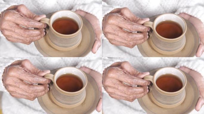 老年妇女手捧一杯绿茶