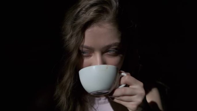 女孩从白杯中愉快地喝咖啡的特写镜头