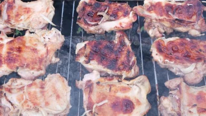 烧烤或烤肉串在户外热煤上的烤架上油炸。在re上煮熟带有外壳的金黄色鸡皮
