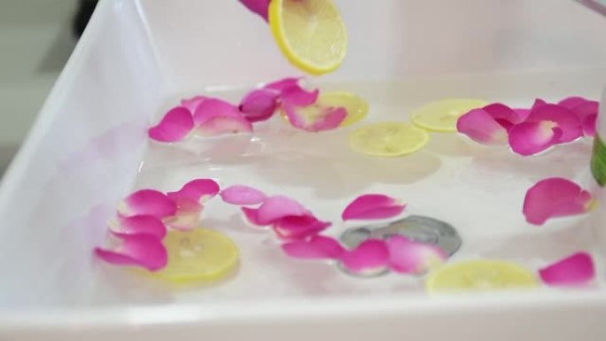 泰国热带花卉碗中足浴。水疗护理和产品为妇女的脚和鞋底。