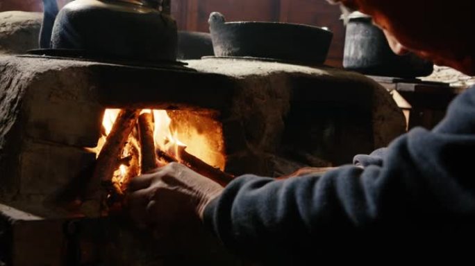 CU-日本高级男子在厨房炉灶上添加木材