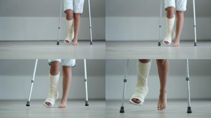 拐杖和断腿的年轻女子在家中散步，断腿事故后康复